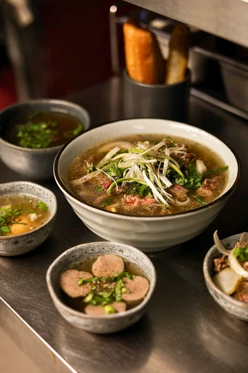 Vietnamese meal with a bowl of phở and fresh accompaniments